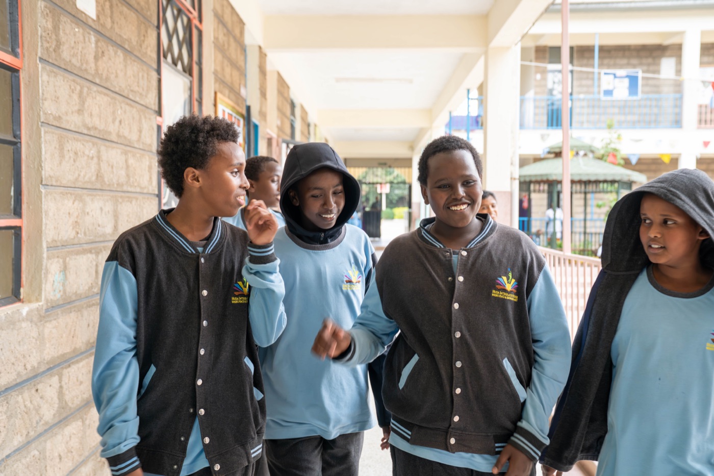 Pupils walking together through a corridor in the academic complex at Huda Integrated School