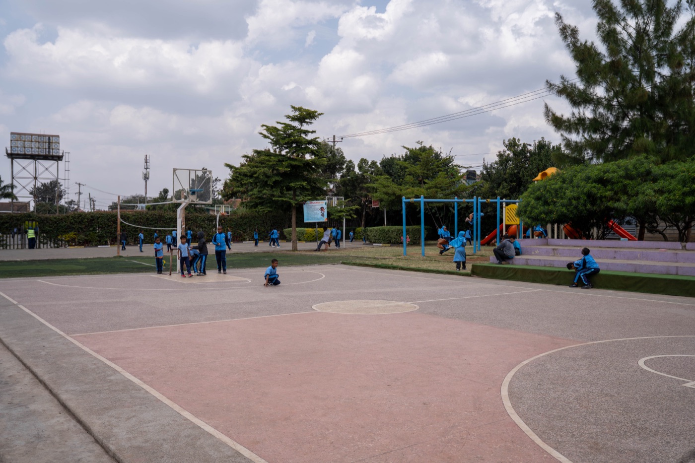 Pupils playing on the outdoor court and grounds at Huda Integrated School